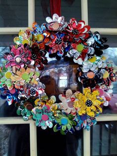 a wreath made out of buttons on the side of a window sill in front of a building