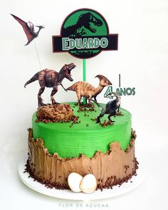 a birthday cake with dinosaurs on it and a sign that says eduarado