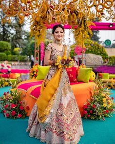 a woman standing under a chandelier with flowers on it