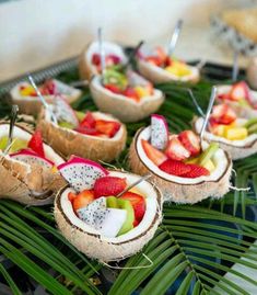 some fruit is cut in half and placed on a plate with palm leaves around it