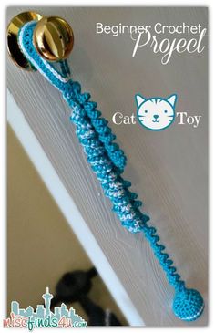 the cat toy is attached to the door handle and has a blue rope on it