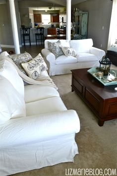 a living room filled with white couches and pillows