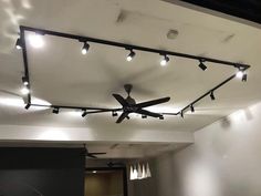 a ceiling fan with lights on it in an empty room that has no people inside