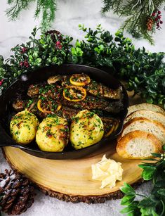 an iron skillet filled with baked potatoes and vegetables