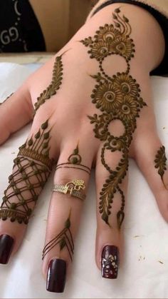 a woman's hand with henna tattoos on it