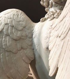 a white statue with wings on it's back