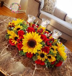 a bouquet of sunflowers and roses sits on a table in front of a couch