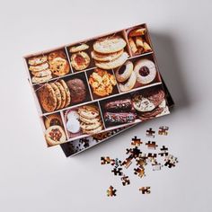 a box filled with assorted cookies and pastries on top of a white table