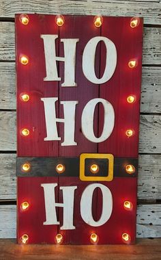 a wooden sign with lights on it that says, oh hohoh and has a santa's hat