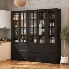 a kitchen with white cabinets and wood floors