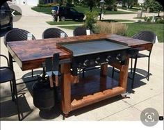 an outdoor bbq table with four chairs around it