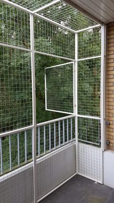 an enclosed area with metal bars on the sides and trees in the backround