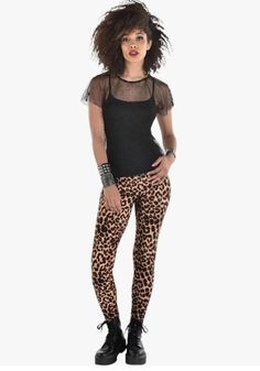 a woman in black shirt and leopard print leggings standing with her hands on her hips