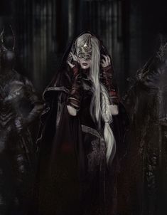 a woman with long white hair standing in front of other demonic looking people wearing masks