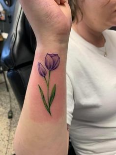 a woman with a purple flower tattoo on her arm