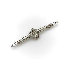 This is part of Chairish’s Fine Jewelry assortment.  This diamond encrusted bar pin dates to 1900’s pre-revolutionary Russia. The center Old European Cut diamond is bezel set with beautiful milgrain work around it. Set in a larger circle element, the diamond is surrounded by cut outs in the shape of a flower with five Rose Cut diamonds bead set into the corners of its petals. This central element is flanked by Rose Cut and Single Cut diamonds along the bar and the pin is topped with a crown moti Diamond Bar, Bead Set, European Cut Diamonds, Rose Cut Diamond, Early 20th Century, Bezel Setting, Cut Outs, Rose Cut, Gold Diamond