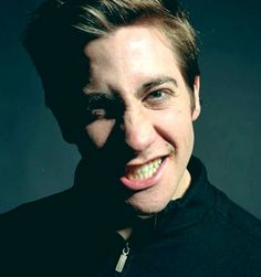 a man smiling with his mouth open in front of a black background and the image is lit up