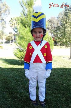 a young boy wearing a red, white and blue uniform while standing in the grass