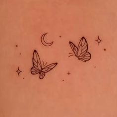 two butterflies flying in the sky with stars and crescent moon tattoos on their back side