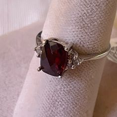 a red stone ring sitting on top of a white napkin