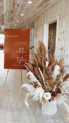 a welcome sign and some dried flowers in a vase