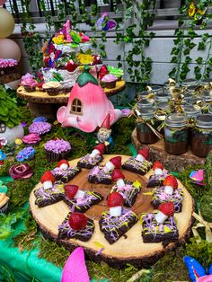 a table topped with lots of desserts and cupcakes on top of wooden slices