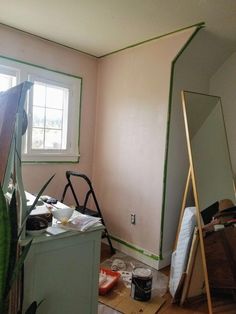 the room is being painted pink and has green trim on the walls, along with other items