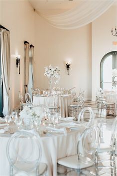 a room filled with tables and chairs covered in white table cloths