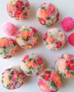 several different colored pom poms on a white surface