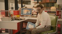 a man sitting in a chair holding a book