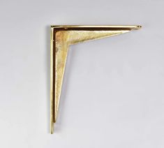 a gold triangle shaped object on a white surface with one corner missing from the wall