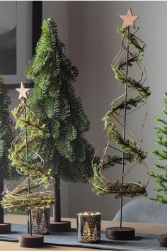 three small christmas trees sitting on top of a table