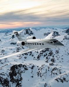 an airplane is flying over the snowy mountains