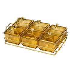 four golden glass dishes on a metal rack