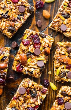 granola bars with nuts and dried fruit on top, lined up on a wooden surface