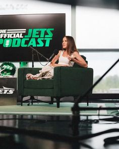 a woman sitting in a green chair on the set of the jets'football show