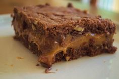 a close up of a piece of cake on a plate with chocolate and caramel topping