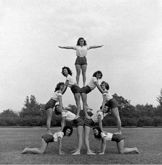 a group of women standing on top of each other in the middle of a circle