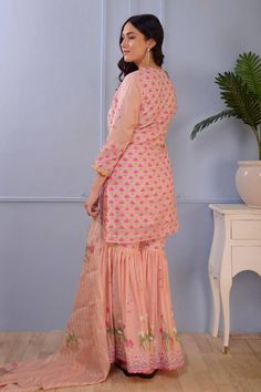 Pink cotton silk kurta with hand block print and lace finish. Comes with foil printed gharara and scalloped viscose organza dupatta with lace finishing.
Component: 3
Pattern: Print
Type Of Work: Foil Print, Hand Block Print
Neckline: Scoop
Sleeve Type: Three quarter
Fabric: Kurta and Gharara: Cotton Silk; Dupatta: Viscose   Stripe Organza
Color: Pink
Other Details: 
Hand block print
Foil print
Scallop dupatta
Occasion: Sangeet - Aza Fashions Pink Unstitched Silk Sharara, Wedding Sharara With Chikankari Embroidery And Peplum Style, Art Silk Sharara With Chikankari Embroidery For Eid, Peplum Sharara With Chikankari Embroidery For Festive, Festive Peplum Sharara With Chikankari Embroidery, Semi-stitched Silk Sharara With Chikankari Embroidery, Designer Chikankari Embroidery Peplum Sets, Designer Wear Peplum Sharara With Chikankari Embroidery, Designer Sharara With Chikankari Embroidery