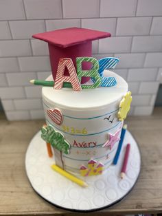 a cake with the letters abc and j on it, decorated like a graduation cap