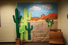 a bulletin board with cactus decorations on it and a wooden chair in the foreground