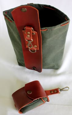 two leather bags sitting next to each other on top of a white surface with one bag in the middle