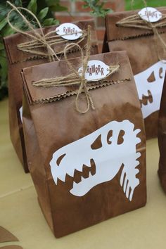 some brown paper bags with white dinosaurs on them