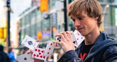 a young man holding playing cards in his hands