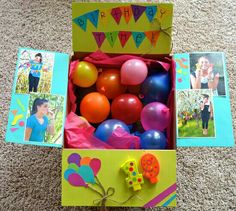 an open birthday box filled with balloons and pictures on the floor next to other items