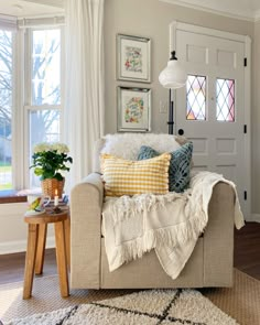 a living room filled with furniture and lots of pillows on top of it's couch