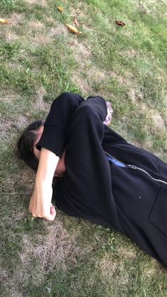 a man laying on the ground with his head in his hands and eyes closed, wearing black sweatpants