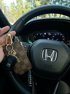 a person holding a car key in their hand while sitting in the driver's seat