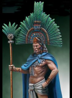 a statue of a man with a spear and headdress