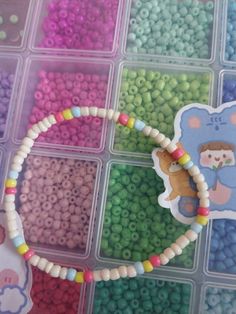 there is a plastic container with beads in it and a bear sticker on the lid